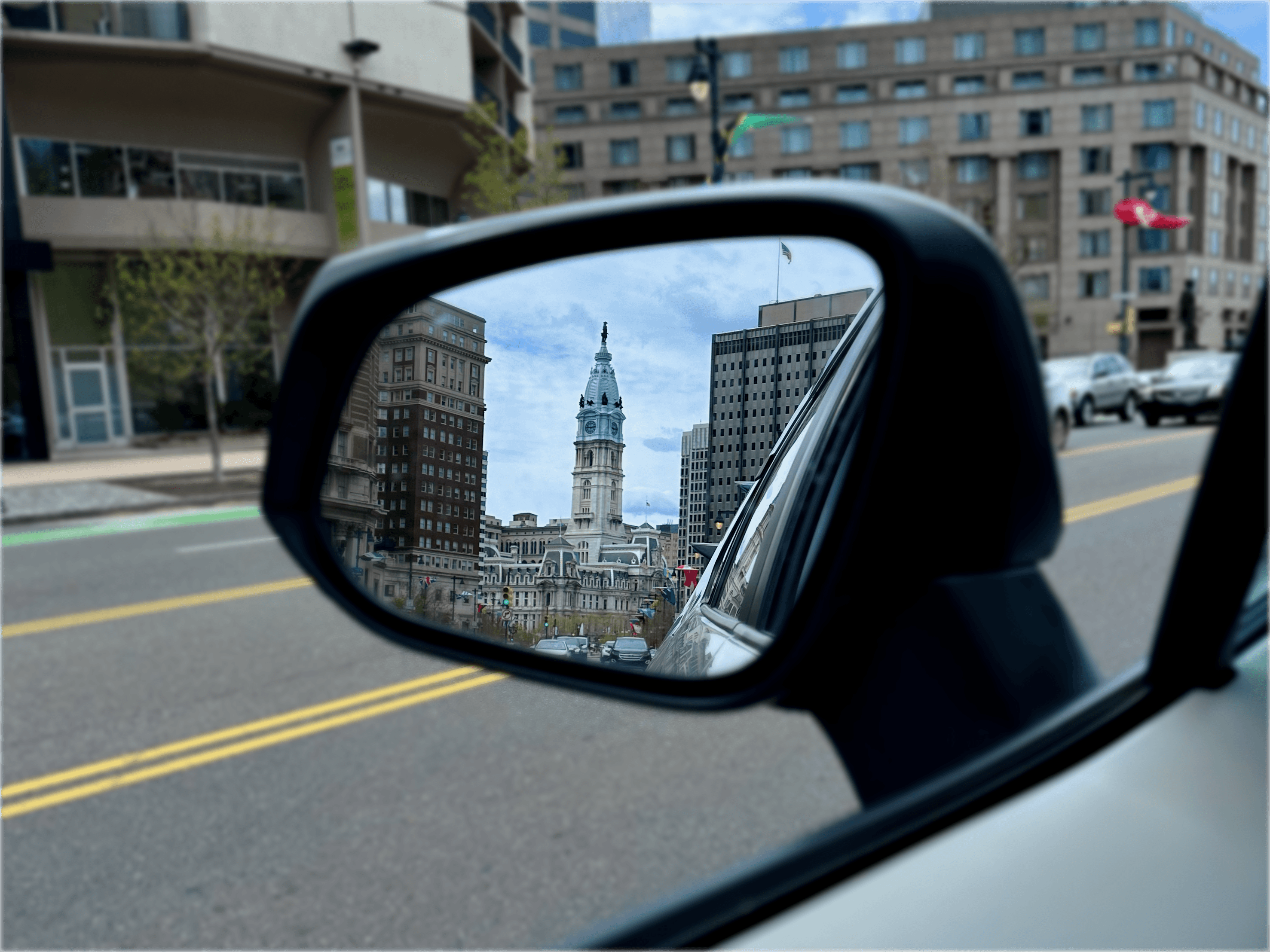 Rearview mirror reflection of Philly Town Hall